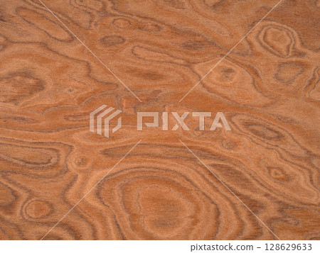 Elm burl veneer surface with a mesmerizing array of cinnamon swirls and deep amber accents 128629633