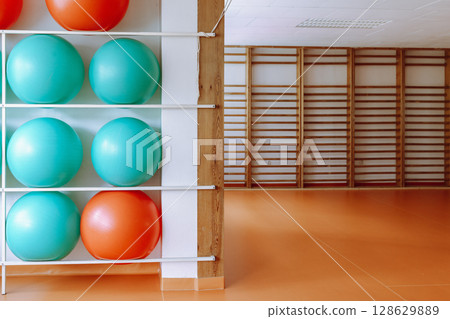 Empty Fitness Studio with Swiss Balls and Wooden Gym Equipment on Display. 128629889