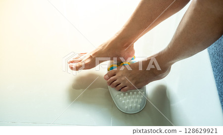 Foot massager in use on a woman legs providing relief while she experiences foot pain Foot massager in use on a woman legs providing relief while she experiences foot pain 128629921