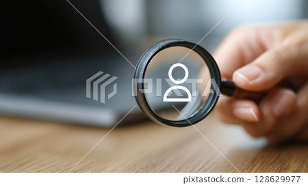 Person icon magnified. Focus on identifying the right person for a role. Finding talent, searching for individuals, recruitment, job search, and hiring. 128629977