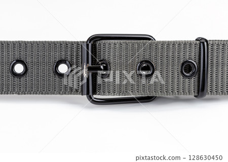 Close up of gray nylon belt with metal buckle, showcasing its texture and design. belt features multiple eyelets and sturdy, sleek appearance, ideal for casual or formal wear 128630450