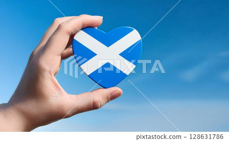 Hand holding Scottish flag heart and blue sky 128631786