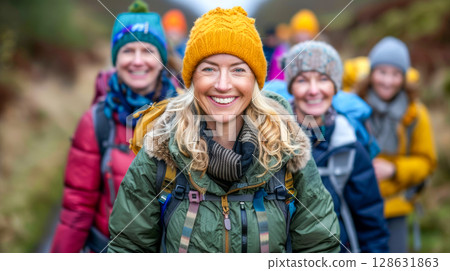 Group of cheerful hikers smiling while trekking through a scenic outdoor landscape together 128631863