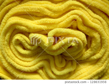bright yellow fleece roll showcasing its soft texture and smooth surface in close-up view. 128631938