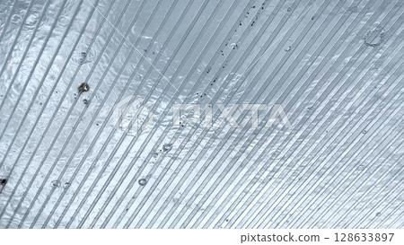 Heavy rain drumming on the transparent plexiglass roof. Beautiful rainy scene on summer day. Concept of tranquility nature scene. Close up Slow motion 128633897
