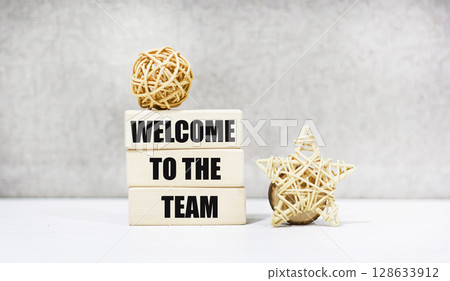 The symbol "Welcome to our team" on the wooden blocks. The background is grey. The symbol "Welcome to our team" on the wooden blocks. The background is grey. 128633912