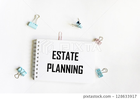 A notebook with the text Real estate planning. Paper clips on a white background. Business concept 128633917