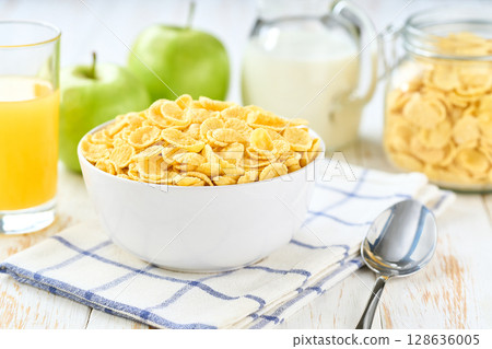 Healthy breakfast with corn flakes and fruits and juice on a white wooden table, selective focus. 128636005