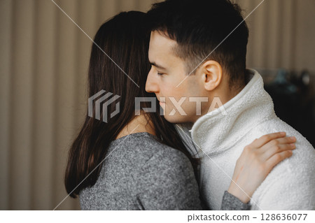 Couple sharing a tender moment indoors during a cozy evening 128636077