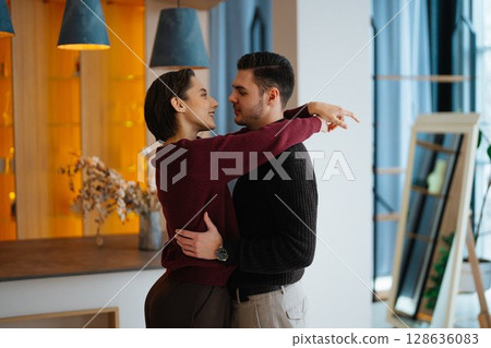 Couple sharing a romantic moment in a cozy modern interior setting 128636083