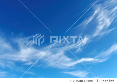 Vibrant midday sky with wispy cirrus clouds drifting across deep blue, ideal for serene backgrounds and nature concept visuals 128636166
