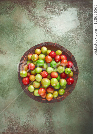 cherry plum tkemali, fruit, plum variety, in a wooden plate, Georgian cuisine, top view, no people, 128636563