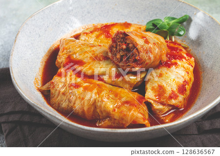 Stuffed cabbage rolls with minced meat, in tomato sauce, top view, without people, in the spotlight. 128636567