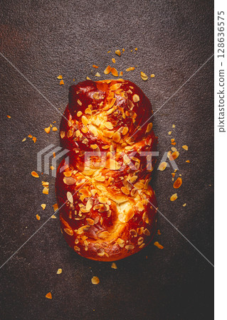 braided, sweet bread pie, with sliced almonds, breakfast, braided bread, brioche, on a dark background, top view, no people, 128636575