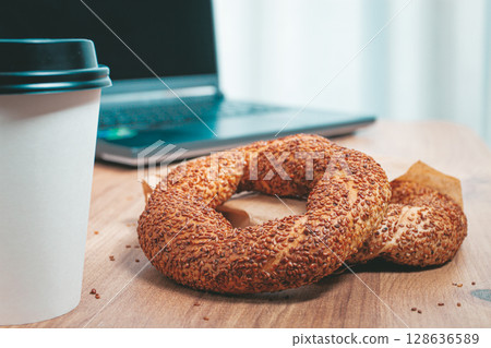 simits with coffee on a wooden table, with a laptop, in a cozy working environment, snack, breakfast, no people, 128636589