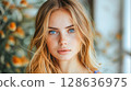 Young woman with blue eyes and blonde hair surrounded by soft floral background in natural light 128636975