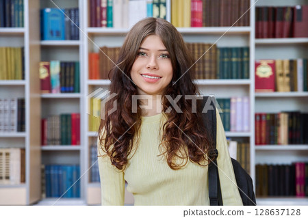 Portrait of teenage beautiful girl high school student posing in library classroom 128637128