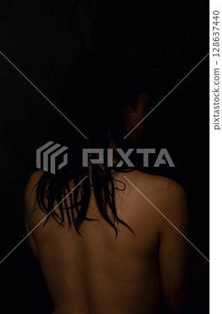 Silhouette of a Woman Gracefully Posed in a Beautifully Dimly Lit Setting with Depth 128637440