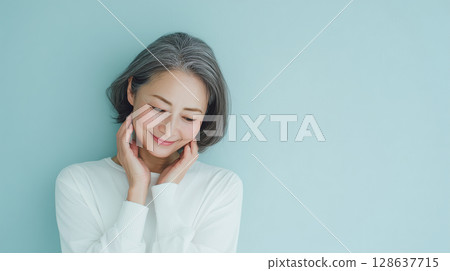 一張由上而下拍攝的照片，一位女士微笑著看著自己的雙手 128637715