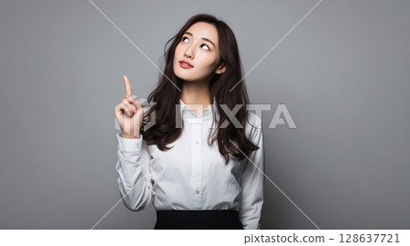 Portrait of a woman showing an idea in a white shirt 128637721