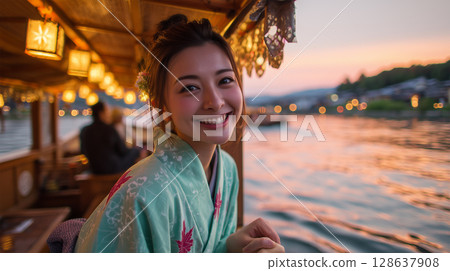 A beautiful woman in a yukata stroking the water in the evening glow of a houseboat 128637908