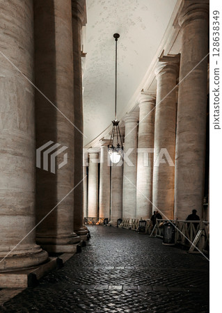 Columns in row close-up. St Peter's Basilica against night sky in Vatican City, Rome, Italy. Vertical photo Columns in row close-up. St Peter's Basilica against night sky in Vatican City, Rome, Italy. Vertical photo 128638349