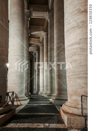Columns in row close-up. St Peter's Basilica against night sky in Vatican City, Rome, Italy. Vertical photo Columns in row close-up. St Peter's Basilica against night sky in Vatican City, Rome, Italy. Vertical photo 128638350