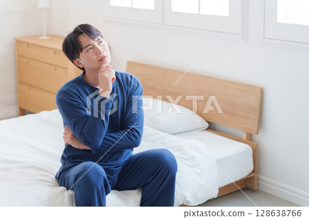 Man thinking in bed 128638766