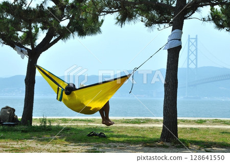 Man relaxing in a hammock at the beach Man relaxing in a hammock at the beach 128641550