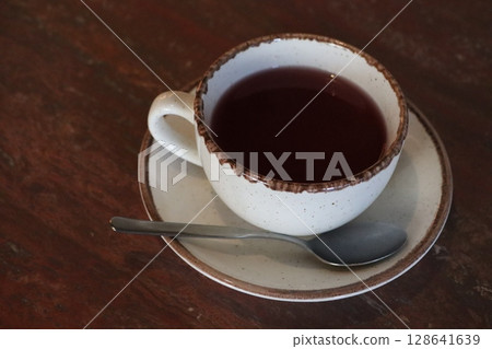 A warm, cozy cup of soothing herbal tea with a delectable chocolate rim on a lovely wooden table A warm, cozy cup of soothing herbal tea with a delectable chocolate rim on a lovely wooden table 128641639