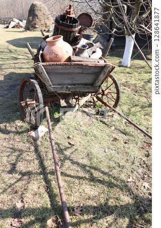 An aged Vintage Wheelbarrow in a charming garden, showcasing craftsmanship and rustic character 128641877