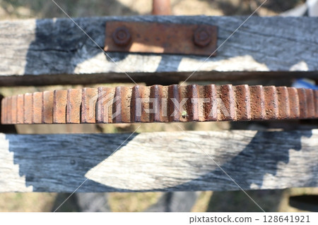A Rusty Gear on a Wooden Structure, showcasing a blend of art and industrial decay 128641921