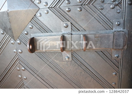 An Intricate and Stunning Metal Door Detail Adorned with Beautiful Rings and Patterns 128642037