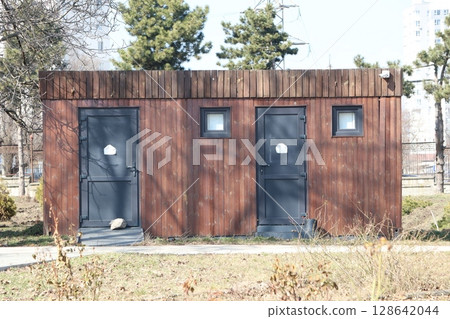 A Rustic Outdoor Restroom Building Designed for Use in a Park Setting, Enhancing Visitor Experience 128642044