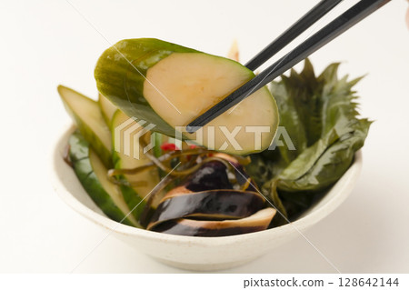 用清湯醃製的夏季蔬菜。用筷子夾起醃菜 128642144