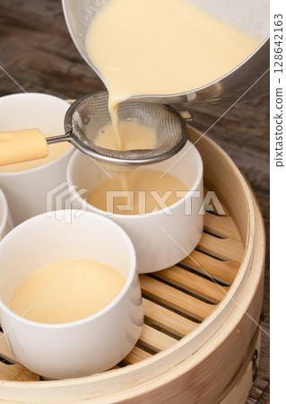 Steamed pudding in a bamboo steamer Steamed pudding Strain the egg mixture through a tea strainer and pour into a mold Steamed pudding in a bamboo steamer Steamed pudding Strain the egg mixture through a tea strainer and pour into a mold 128642163