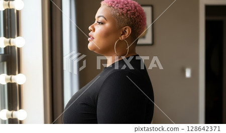 Confident African American Woman with Pink Pixie Cut in Black Outfit by Window Confident African American Woman with Pink Pixie Cut in Black Outfit by Window 128642371