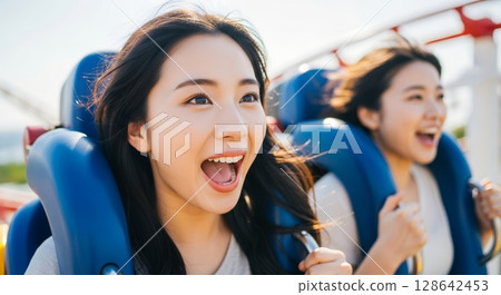 Two women enjoying a roller coaster 128642453