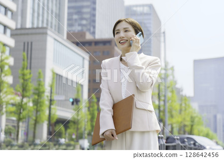 一位年輕女商人在辦公區用智慧型手機交談的畫像 128642456