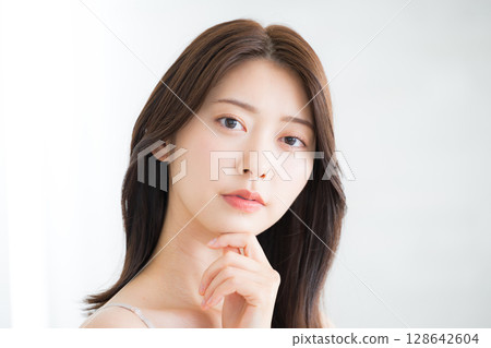 Beautiful young woman with beautiful bare skin, pose thinking with hand on chin, beauty and beauty image, looking at camera 128642604