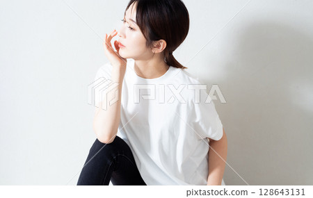Portrait of a young woman sitting on the floor 128643131