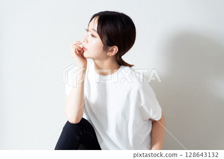 Portrait of a young woman sitting on the floor 128643132