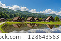Shirakawa-go Gassho-zukuri style houses reflected in the rice fields in summer 128643563