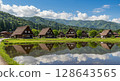 Shirakawa-go Gassho-zukuri style houses reflected in the rice fields in summer 128643565
