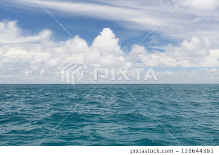 Ocean waves with turquoise water and white clouds 128644361