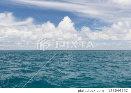 Ocean waves with turquoise water and white clouds 128644362