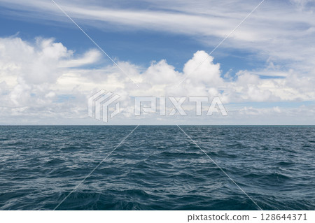 Ocean waves with turquoise water and white clouds 128644371