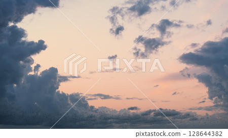 Evening clouds in the sky in summer evening with warm light 128644382