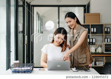 Portrait of success business people working together in office. Couple teamwork startup concept Portrait of success business people working together in office. Couple teamwork startup concept 128645072