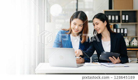 Businesswoman leading team meeting and using tablet and laptop computer with financial in office Businesswoman leading team meeting and using tablet and laptop computer with financial in office 128645189